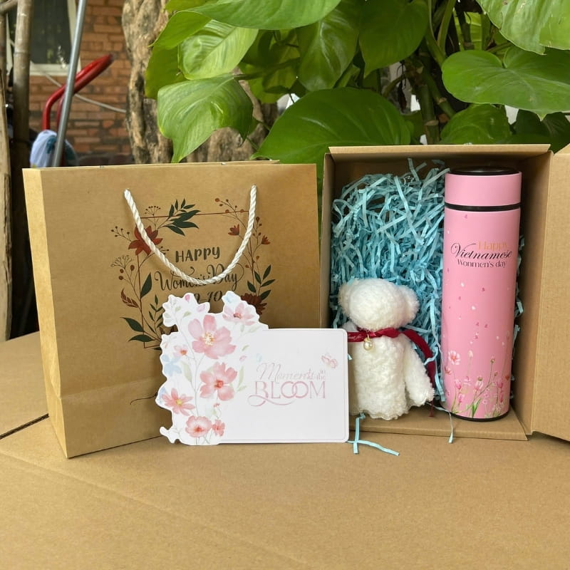 Set quà tặng 20/10 gồm bình giữ nhiệt hồng in lời chúc và khăn mặt trắng hình gấu đựng trong hộp carton